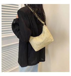Détail du sac hobo en paille tressée naturelle porté à l'épaule pour femme
