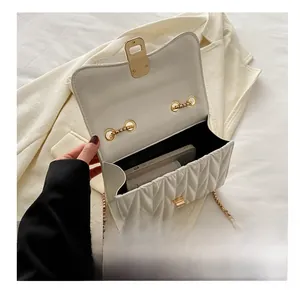 Vue ouverte du sac matelassé blanc montrant l'espace pour téléphone et rouge à lèvres