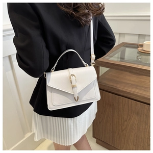 Lifestyle view of a woman wearing a white crossbody bag with a sleek metal clasp closure