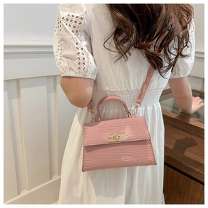 Petit sac carré rose à texture crocodile avec fermoir tournant doré et poignée