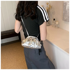 Detail of silver metallic cloud bag with wrinkled leather texture and slim strap