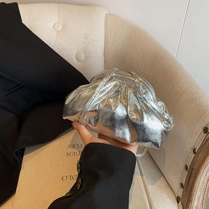 Detail of silver metallic cloud bag with gathered pleated texture and thin shoulder strap