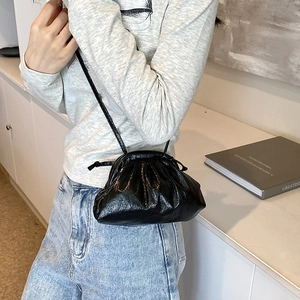 Minimalist black pleated cloud bucket bag with slim shoulder strap for women