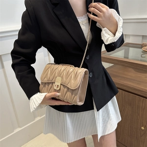 Sac à bandoulière beige matelassé avec chaîne dorée et fermoir pivotant en métal