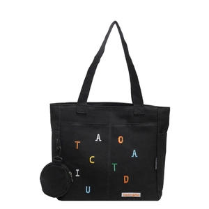 Black canvas tote bag with colorful embroidery and round coin purse on white background