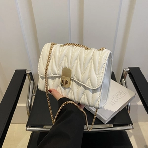 Détail du sac à main matelassé blanc avec surpiqûres ondulées et fermoir doré