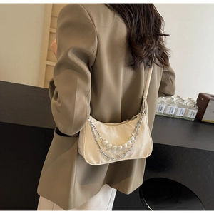Cream leather shoulder bag detail with silver chain and white faux pearls on model