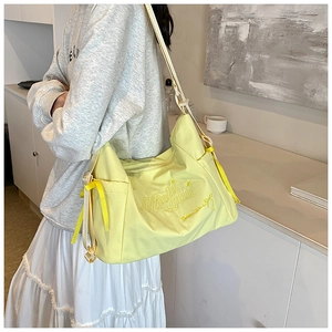 Close-up of yellow tote bag with Michigan embroidery and decorative ribbon detail