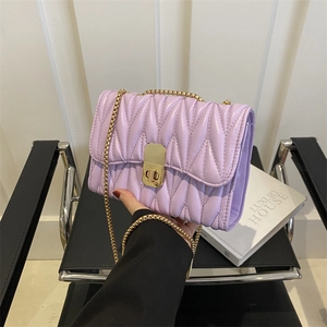 Détail du sac à chaîne matelassé violet clair avec fermoir doré et bandoulière fine