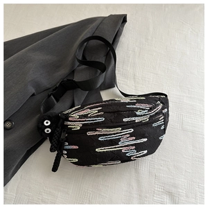 Detail of black crossbody bag featuring colorful embroidery and textured pattern