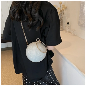 Detail view of silver spherical evening bag with rhinestone handle and metal chain