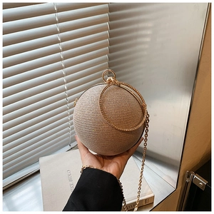 Detail of spherical gold glitter evening bag with rhinestone-encrusted ring handle