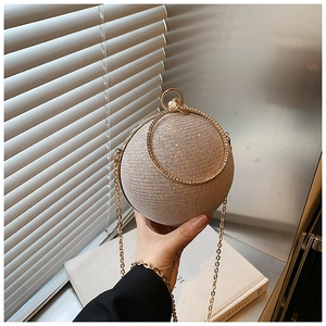 Detail of glitter sphere evening bag with rhinestone ring handle and gold chain strap