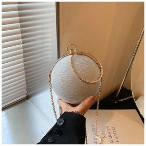 Detail of silver spherical clutch bag with sparkling sequins and gold ring handle