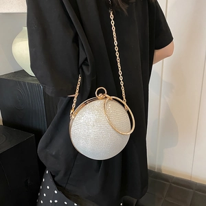 Sparkly silver spherical clutch bag with golden metal handle and fine chain strap