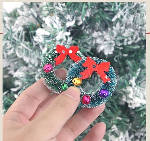 Dettaglio di mini ghirlande natalizie con fiocchi rossi e piccoli campanelli colorati