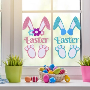 Close-up of glitter Easter bunny window stickers in pink and blue on a glass surface
