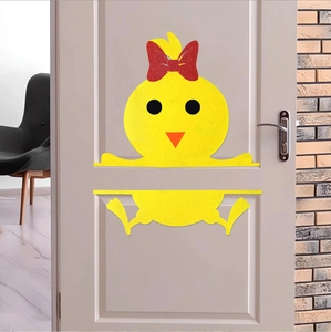 Detail of yellow Easter chick wall decal with a red glitter bow on a white indoor door