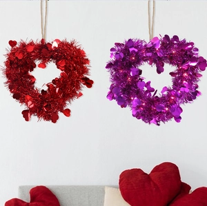 Detail of red and purple heart tinsel wreaths with shiny sequins for Valentine party decor