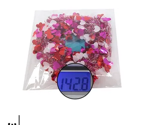 Weight measurement of heart tinsel wreath in plastic packaging at 142.8g for party decor