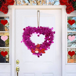 Red tinsel heart wreath with LOVE sign and cute gnome hanging on a white door decor