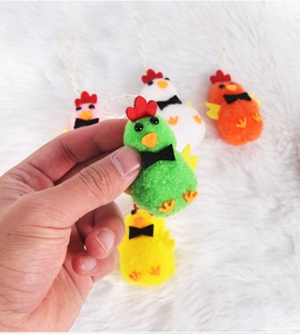 Detalle de pollitos de Pascua de peluche coloridos con crestas de fieltro y lazos para colgar