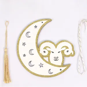Detail of wooden crescent moon and ram hanging decoration with golden tassel and glitter