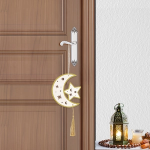 White Eid moon and star wooden ornament with golden tassel hanging on a door handle