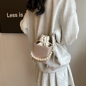 Summer woven bucket bag featuring a pearl handle and gold chain shoulder strap for women