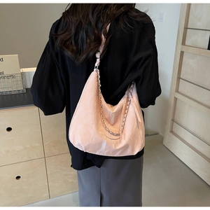 Detail of soft pleated fabric on a pink large hobo bag with stylish silver chain strap