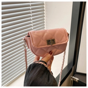 Detailed shot of pink quilted mini crossbody bag with silver chain and metal turn lock