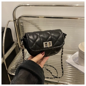 Close-up of black quilted leather saddle bag with silver metal twist lock and chain strap