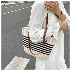 Detail der gestreiften gewebten Shopper-Tasche mit Ledergriffen an einem Model