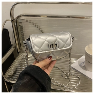 Detail of silver quilted crossbody saddle bag with metallic chain and turn-lock closure