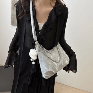 Borsa hobo argento con trama plissettata, catena e ciondolo a orsetto indossata da modella