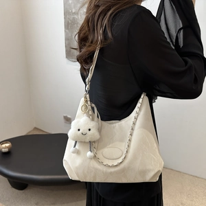 Borsa tote a mezzaluna crema con catena argento e ciondolo a nuvola soffice su modella