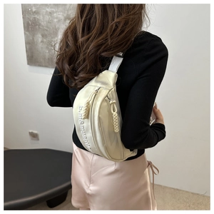 Détail du sac banane argenté métallisé avec broderie et tirettes de fermeture tressées