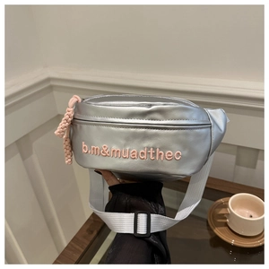 Détail du sac banane argenté avec broderie rose et fermeture à glissière tissée