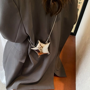 Silver star-shaped crossbody bag with metallic mirror finish and delicate chain strap