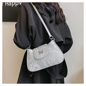 Detail of marble pattern shoulder bag with a silver butterfly metal buckle closure