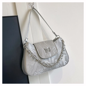Detail of silver crescent bag with marble texture and butterfly metal buckle