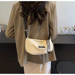 Chic beige half-moon crossbody bag with textured leather and trendy wide strap detailing