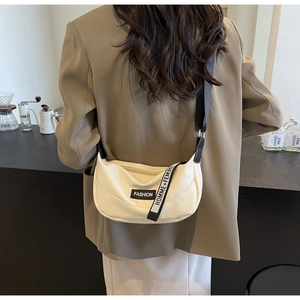 Detail of off-white crescent crossbody bag with fashion letter patch and woven strap