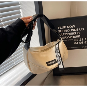 Detail of off-white lychee leather bag with black FASHION label and lettered ribbon