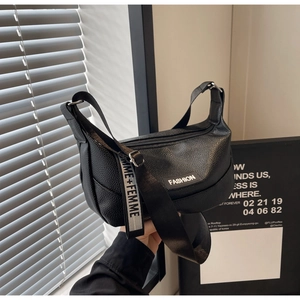 Detailed view of black litchi pattern half-moon bag with adjustable lettered strap