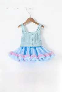Dettaglio del gilet in maglia traforata con fiocco e gonna tutu per bambine