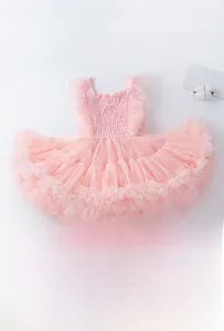 Détail d'une robe tutu rose avec mesh multicouche volumineux et manches à volants