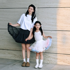 Detail view of mother and daughter wearing matching layered mesh tutu skirts in a modern style