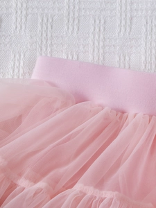 Detailed close-up of pink layered mesh tulle fabric and elastic waistband on girls tutu skirt
