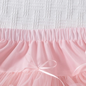 Detailed view of elastic waistband with a silk bow on a pink tulle tutu skirt